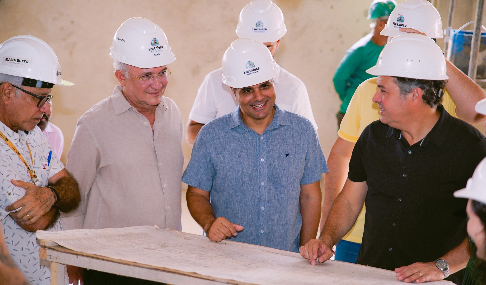 grupo de pessoas olha a planta de uma obra